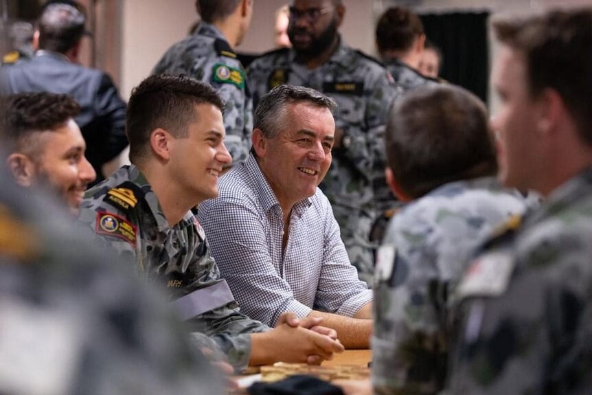 MP Darren Chester sits and laughs with navy crews