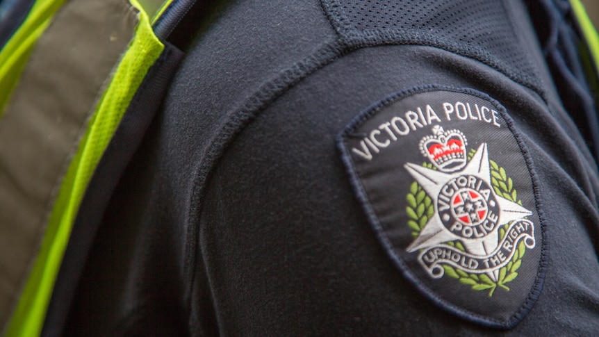 A close up of a police badge on a uniform, says Victoria Police, Uphold the rights.