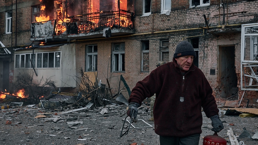 A local resident leaves his home after Russian shelling.