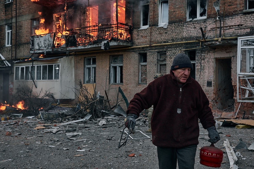 A local resident leaves his home after Russian shelling.