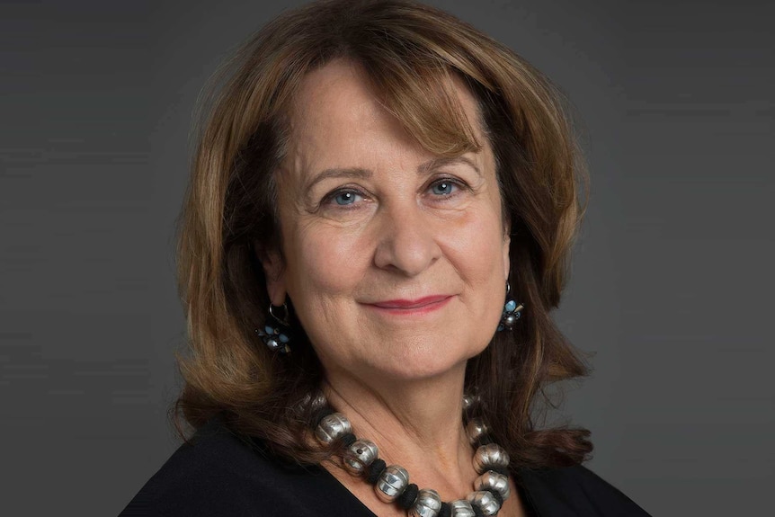 A woman with brown hair smiles.