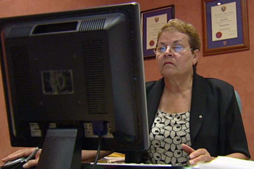 A woman sits looking at her computer