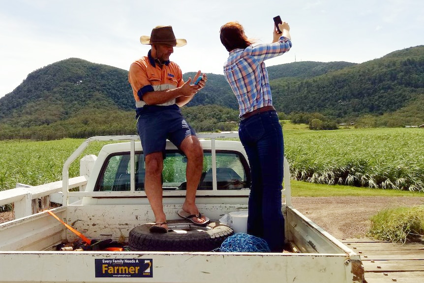 Reporter Lara Webster out and about covering the impact of the cyclone in the back of a ute