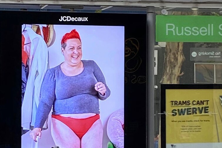 A billboard showing a plus-sized model in red underpants