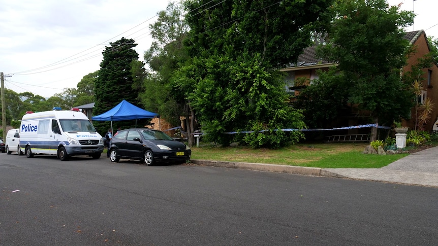 A brick home in a suburban area that has been cordoned off with police tape.