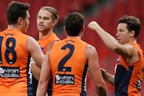 GWS Giants AFL players in a huddle as they celebrate a goal against Geelong.