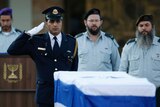 A guard salutes near the coffin of Arial Sharon