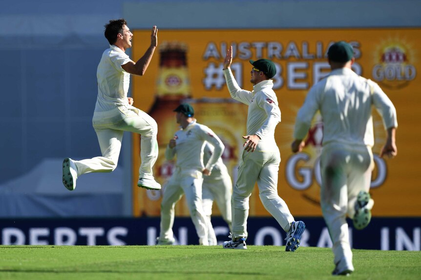Australian bowler Pat Cummins (L) reacts after dismissing England batsman Mark Stoneman on day one.