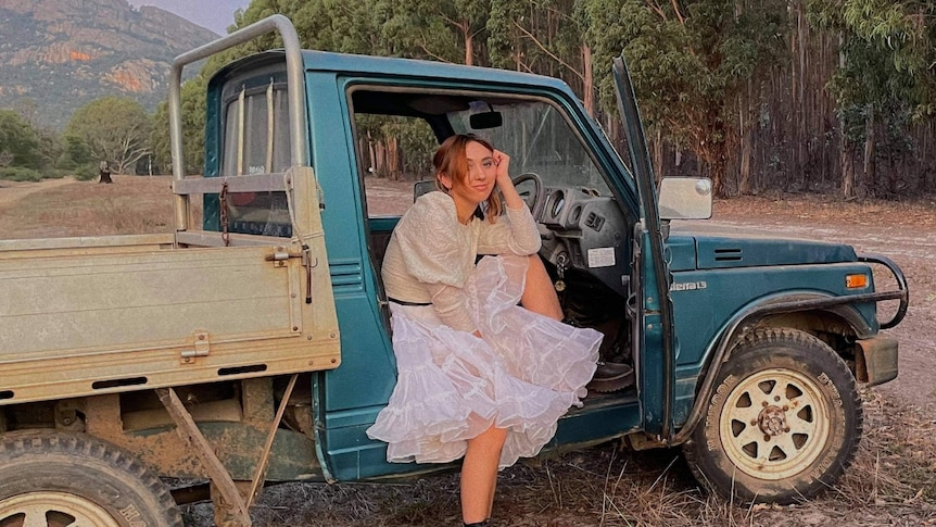 Alice Skye sits in the drivers seat of a blue ute with the door open