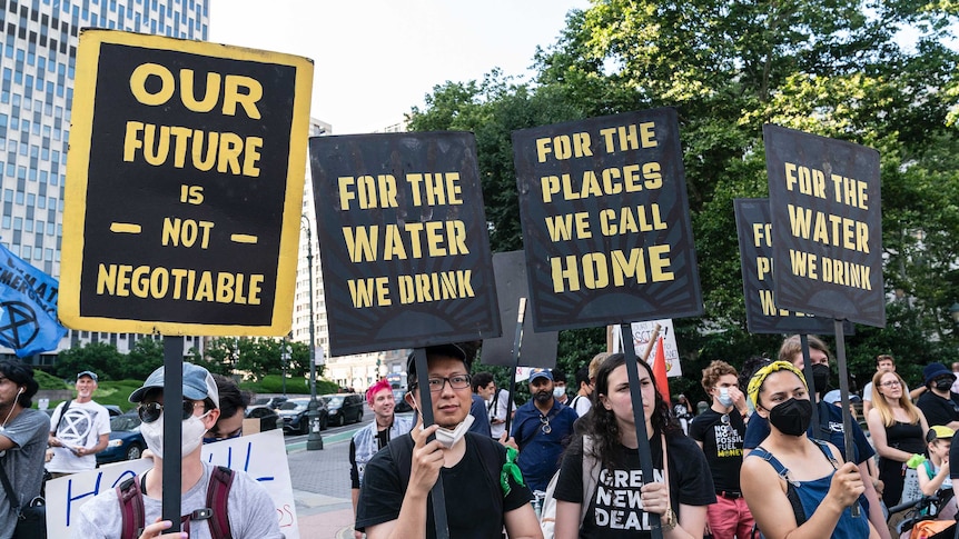 Activists rally holding signs related to environment following Supreme Court decision against Environmental Protection Agency