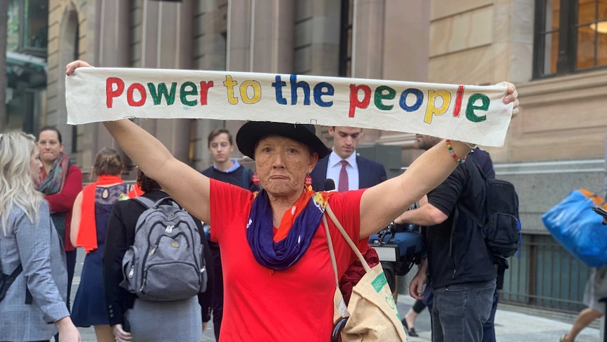 A climate change protester holds up a sign.