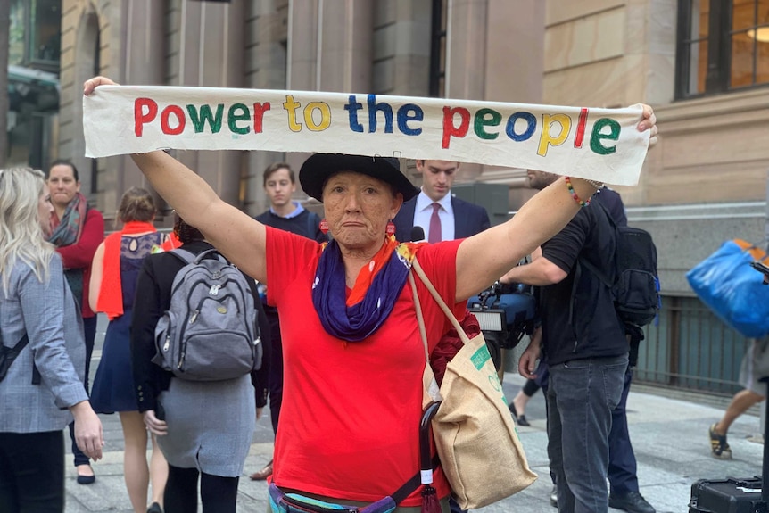 A climate change protester holds up a sign.