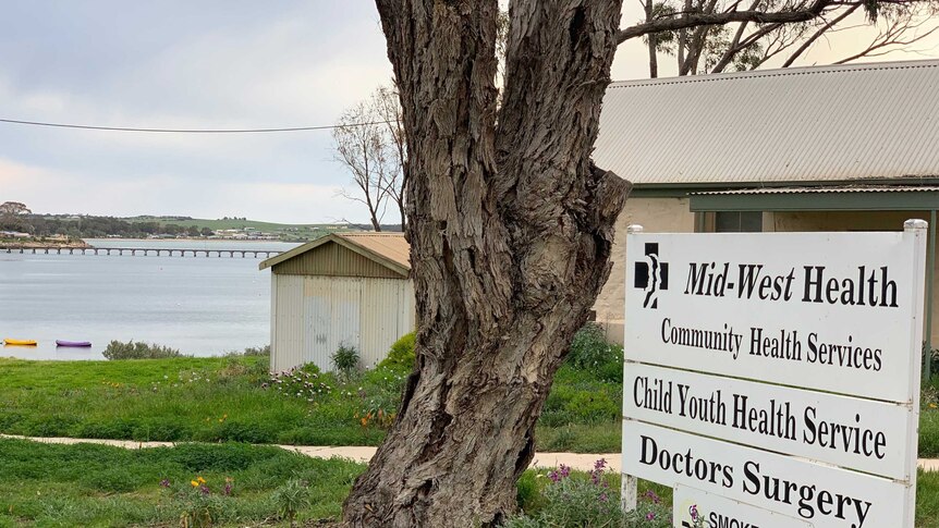 A photo of the Streaky Bay medical clinic sign with the sea in the background.