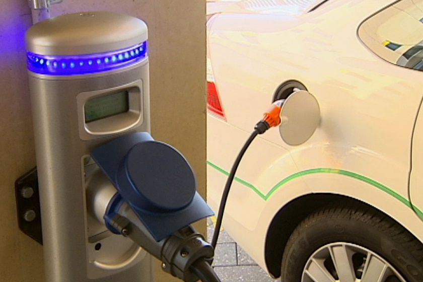 An electric vehicle plugged in at a charging point.