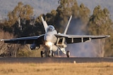 A Super Hornet lands on a runway 