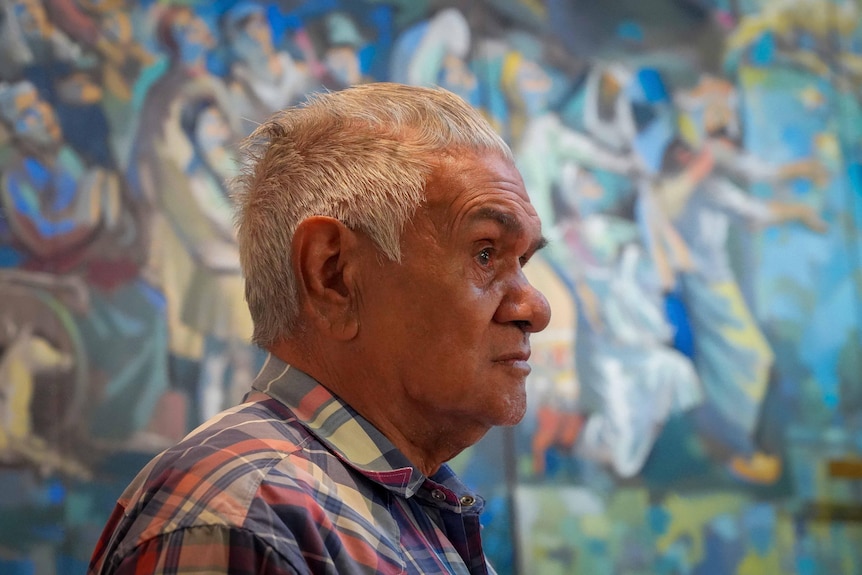 A man in front of a mural