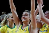 Liz Watson smiles as she waves both arms to the crowd following Australia's netball win over South Africa