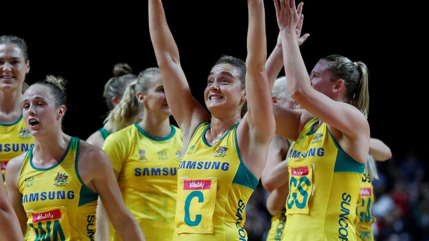 Liz Watson smiles as she waves both arms to the crowd following Australia's netball win over South Africa