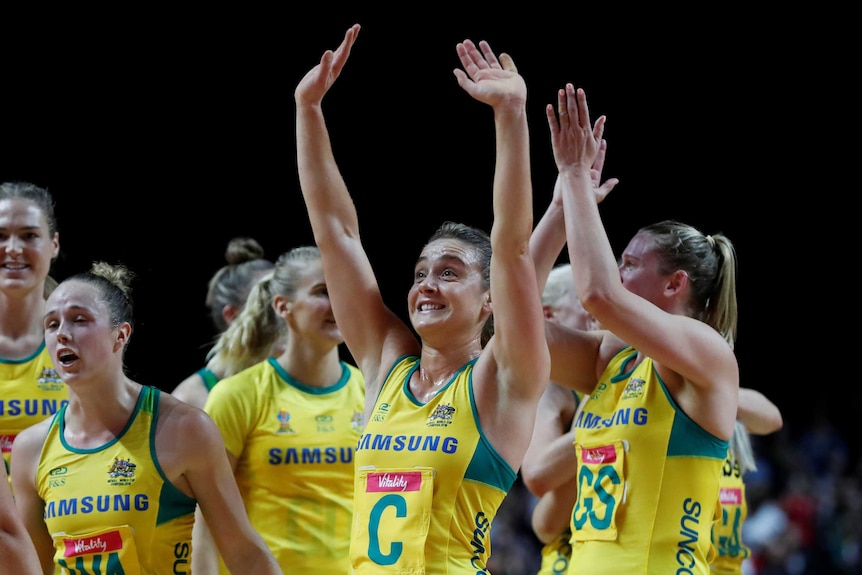 Liz Watson smiles as she waves both arms to the crowd following Australia's netball win over South Africa