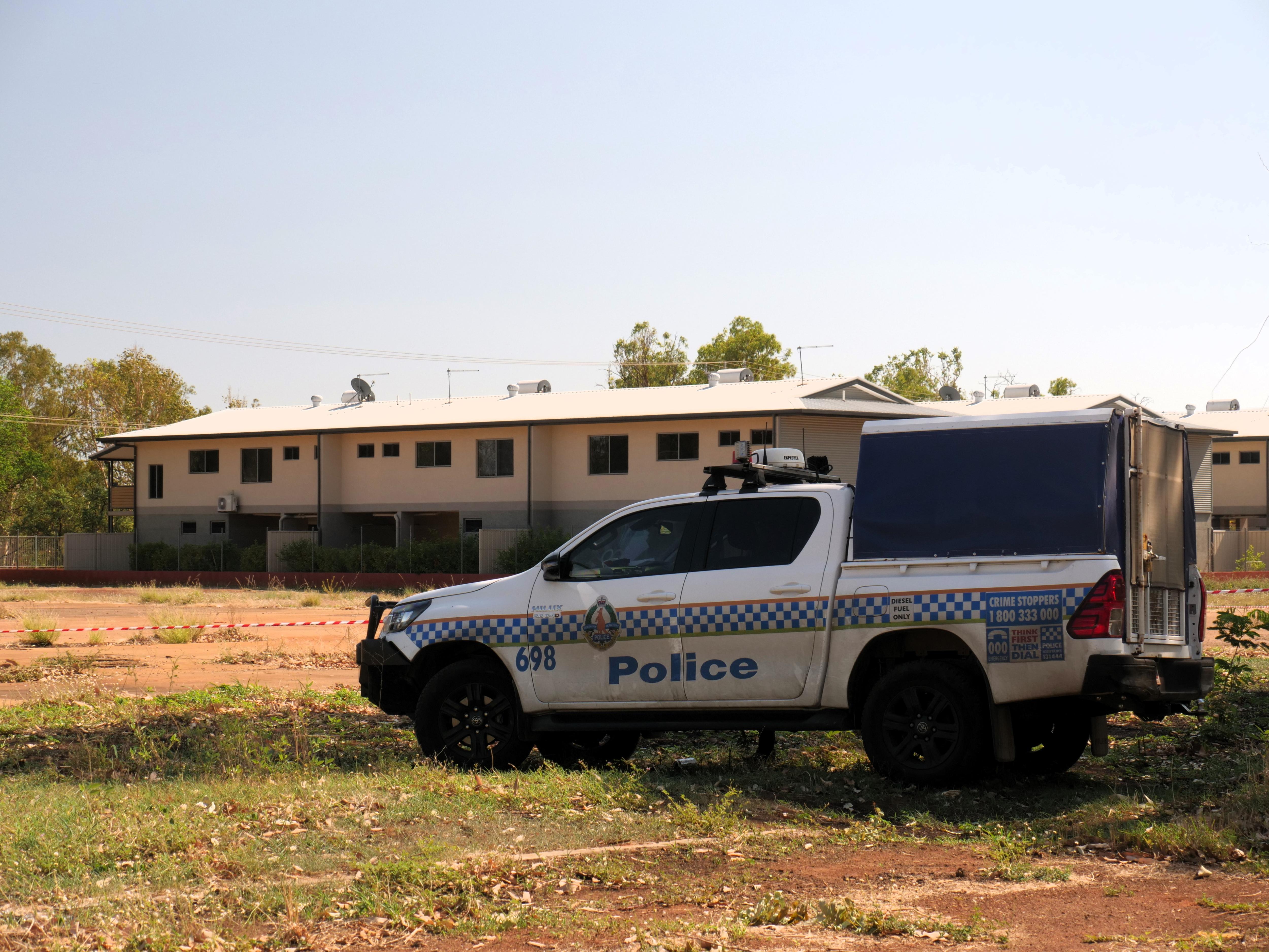 An NT police vehicle parked outside a unit complex and an empty block of land in Katherine.