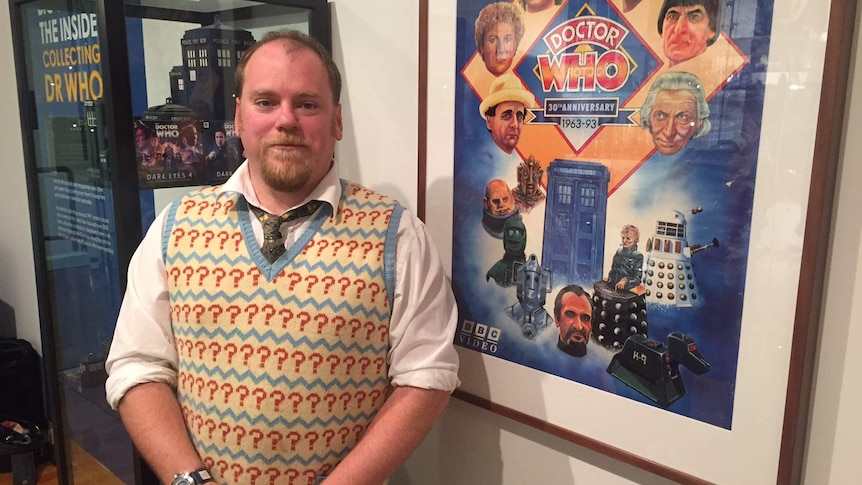 Tim Krisopp stands in front of a Dr Who poster at the Canberra Museum and Gallery