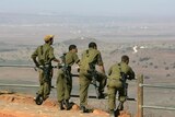 Israeli soldiers watch from Golan Heights
