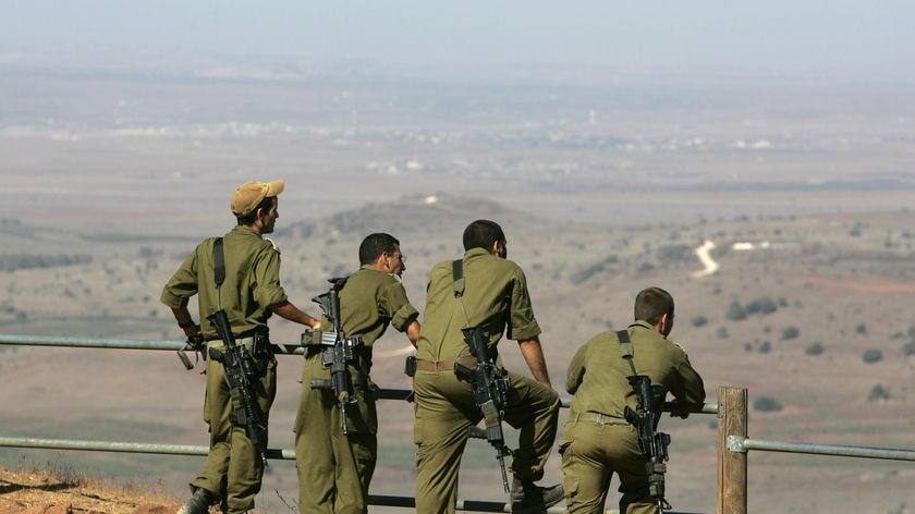 Israeli soldiers watch from Golan Heights