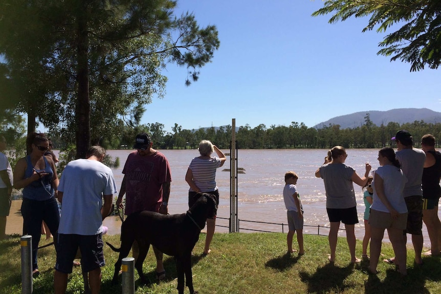 People watch waters rise in the Fitzroy River in Rockhampton on April 2, 2017 ahead of predicted flood