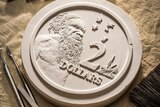 The original plaster cast of the $2 coin with sculpting tools.