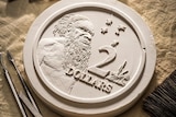 The original plaster cast of the $2 coin with sculpting tools.