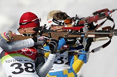 Michael Greis (left) competes at the shooting range during the biathlon