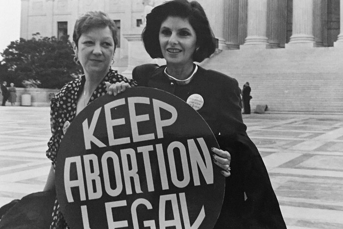 Black and white photograph of Gloria Allred, the lawyer for Norma McCorvey in Roe v Wade holding a Keep Abortion Legal sign