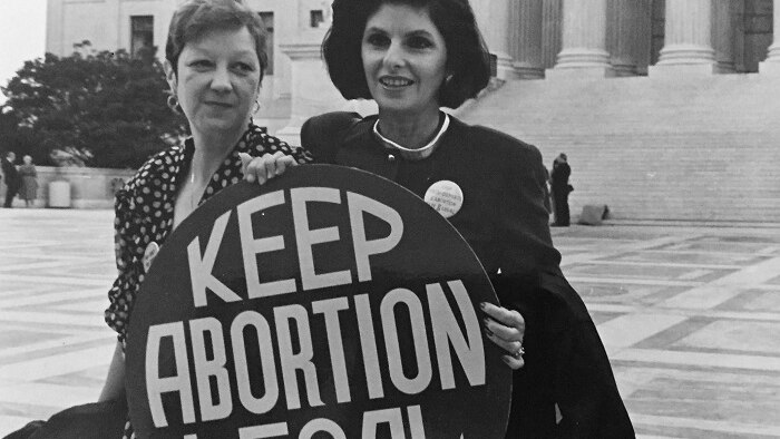 Black and white photograph of Gloria Allred, the lawyer for Norma McCorvey in Roe v Wade holding a Keep Abortion Legal sign