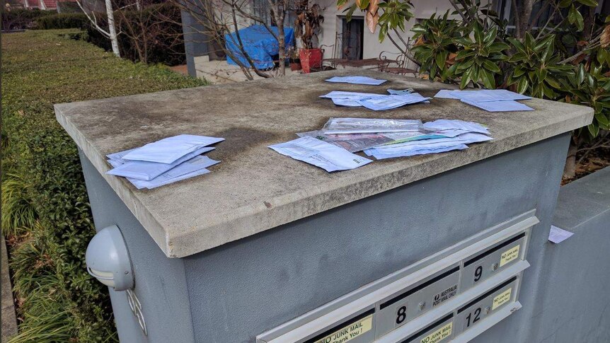 Soggy mail on top of a letterbox.