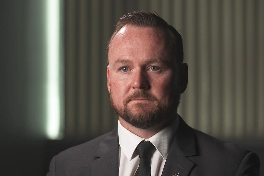 A man with a beard wearing a suit and tie.