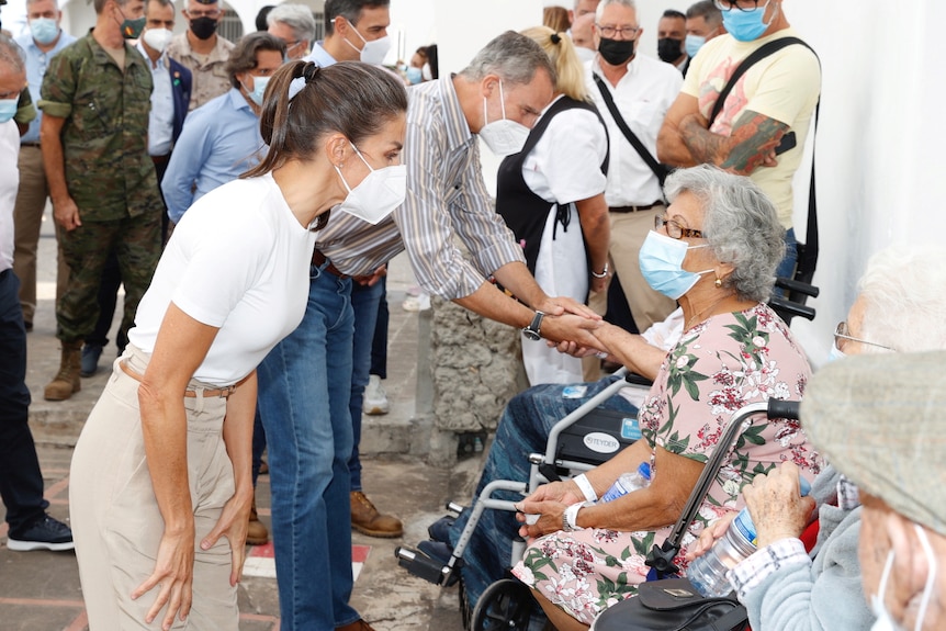 Un hombre y una mujer saludan y confortan a los evacuados en un edificio