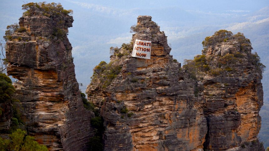 Climate change banner hangs from the Three Sisters