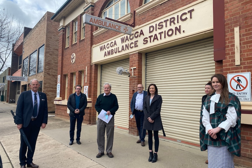 Four men and three women standing in front of the old, red brick ambulance station in Wagga Wagga