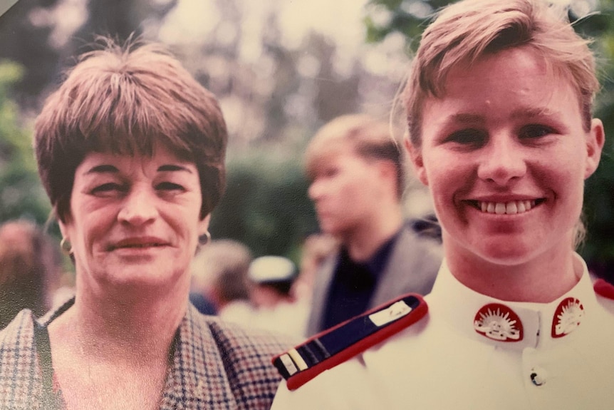 A woman in a defeence uniform stands next to her mother. Both are smiling.