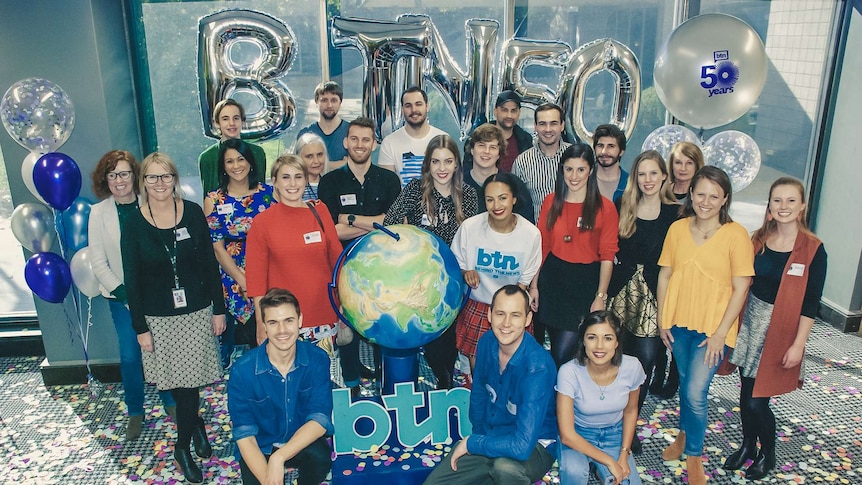 Balloons surround the staff of BTN in 2018. Also in photo is the old atlas that was used on many shows in the past.