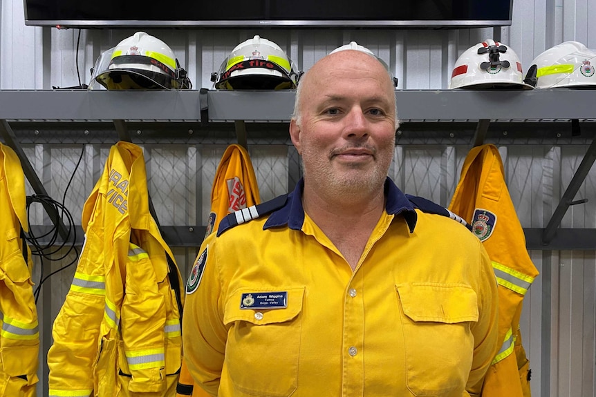 A man stands in RFS uniform in front of hung up uniforms