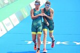 An Australian para-triathlete grimaces as she and her sighted guide run over the line at the end of the para-triathlon in Tokyo.