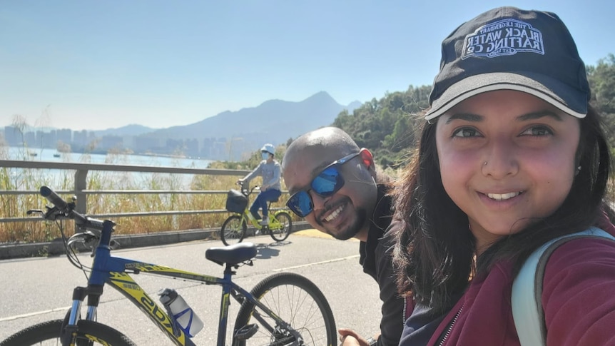 a young woman wearing a cap sitting with a man at a bicycle track