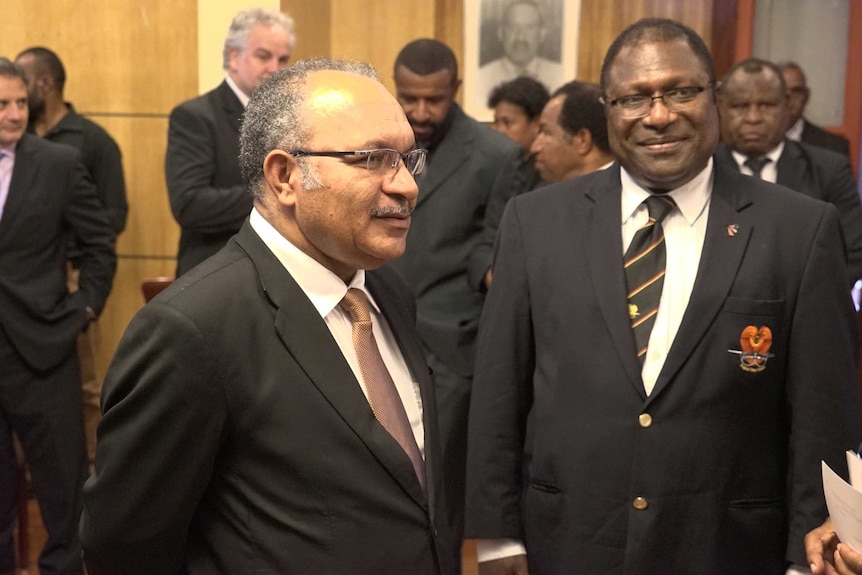 PNG Prime Minister Peter O'Neill stands to the right of Electoral Commissioner Patilias Gamato