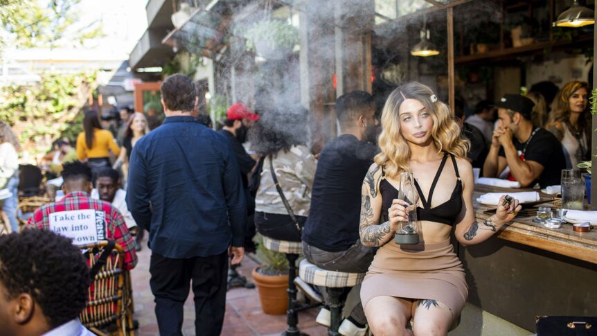 A woman smokes marijuana in a cafe