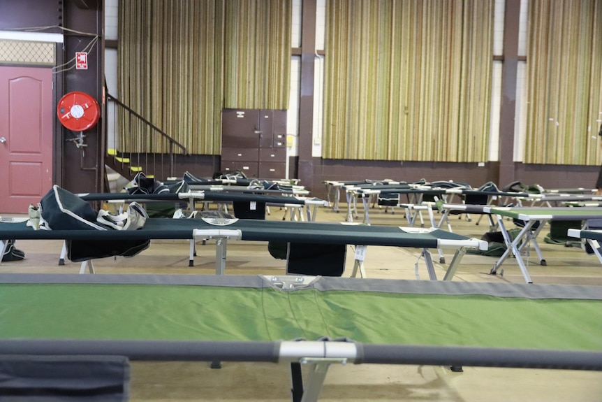 An empty room with empty beds set up for evacuees. 