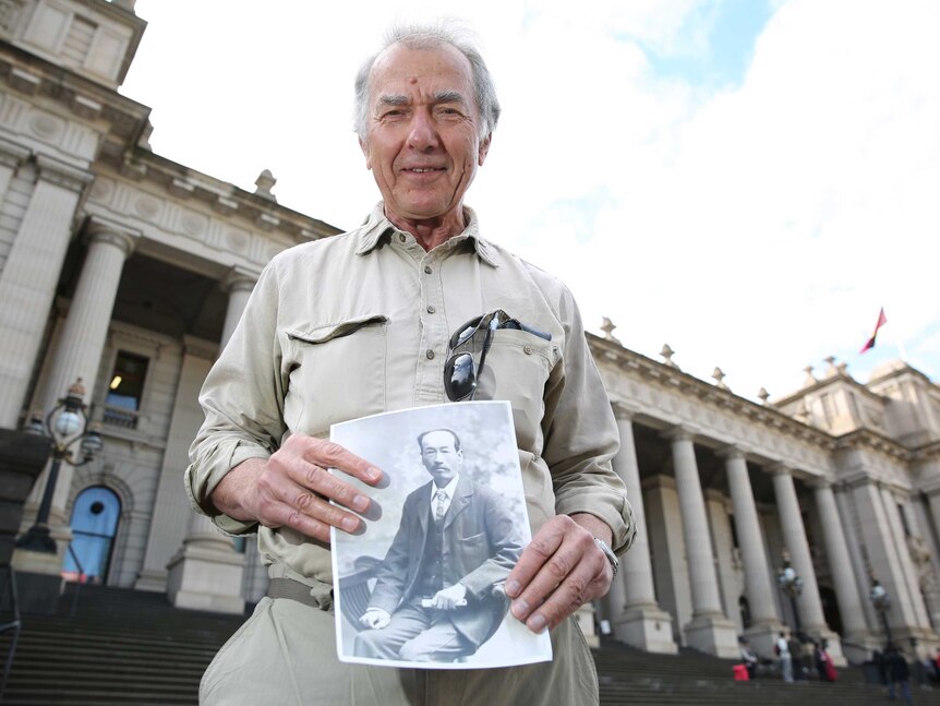 Max Brady holds a photo of Wong Ah Sat outside Parliament House