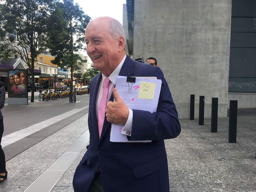 Alan Jones smiles outside Brisbane's Supreme Court.