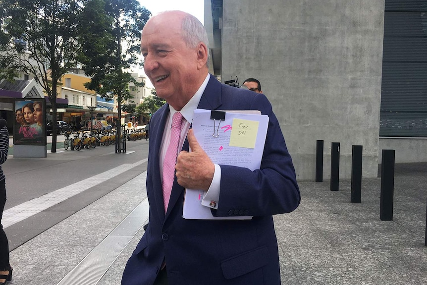 Alan Jones smiles outside Brisbane's Supreme Court.