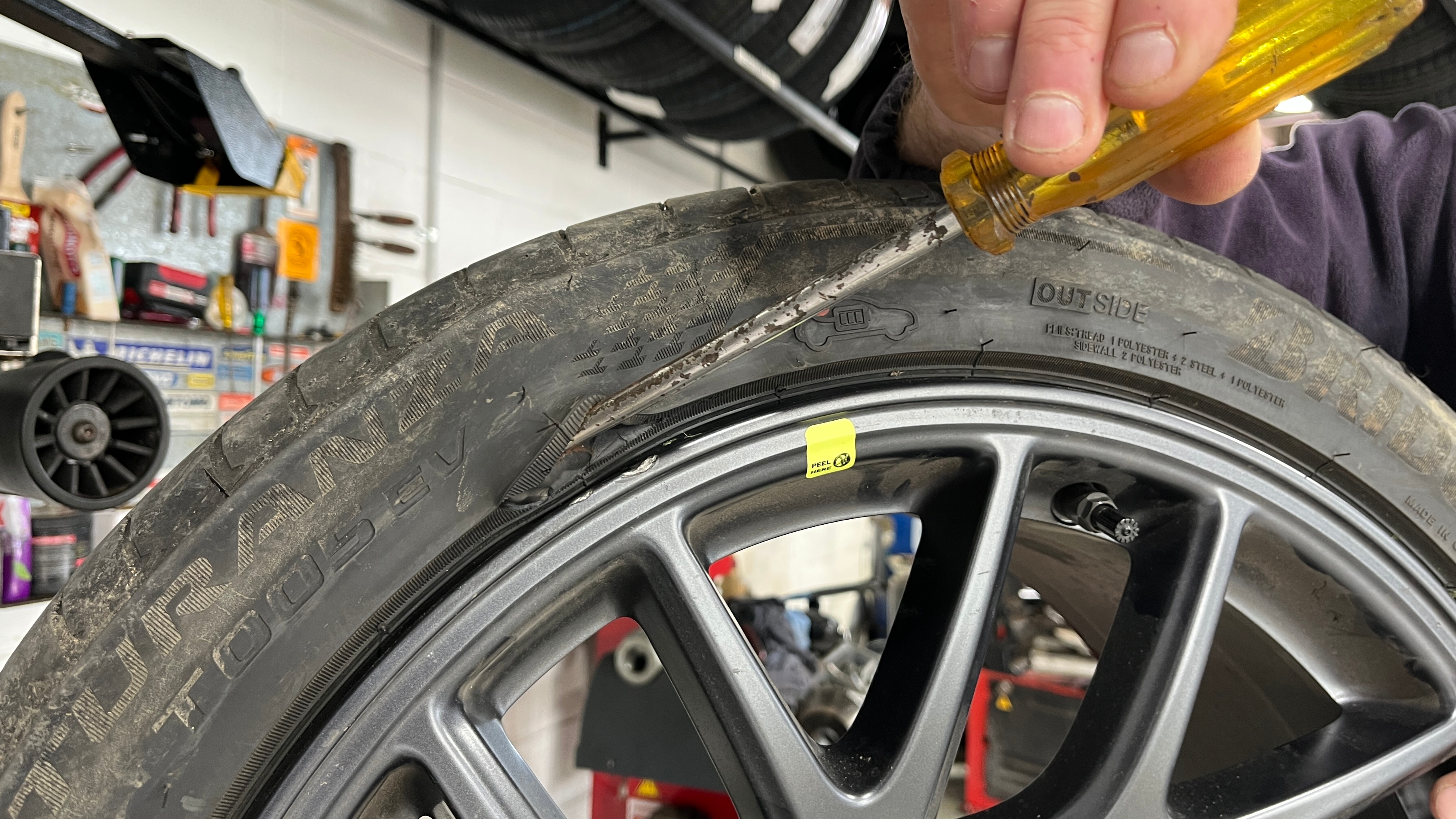 a screwdriver is held on a hole in a tyre